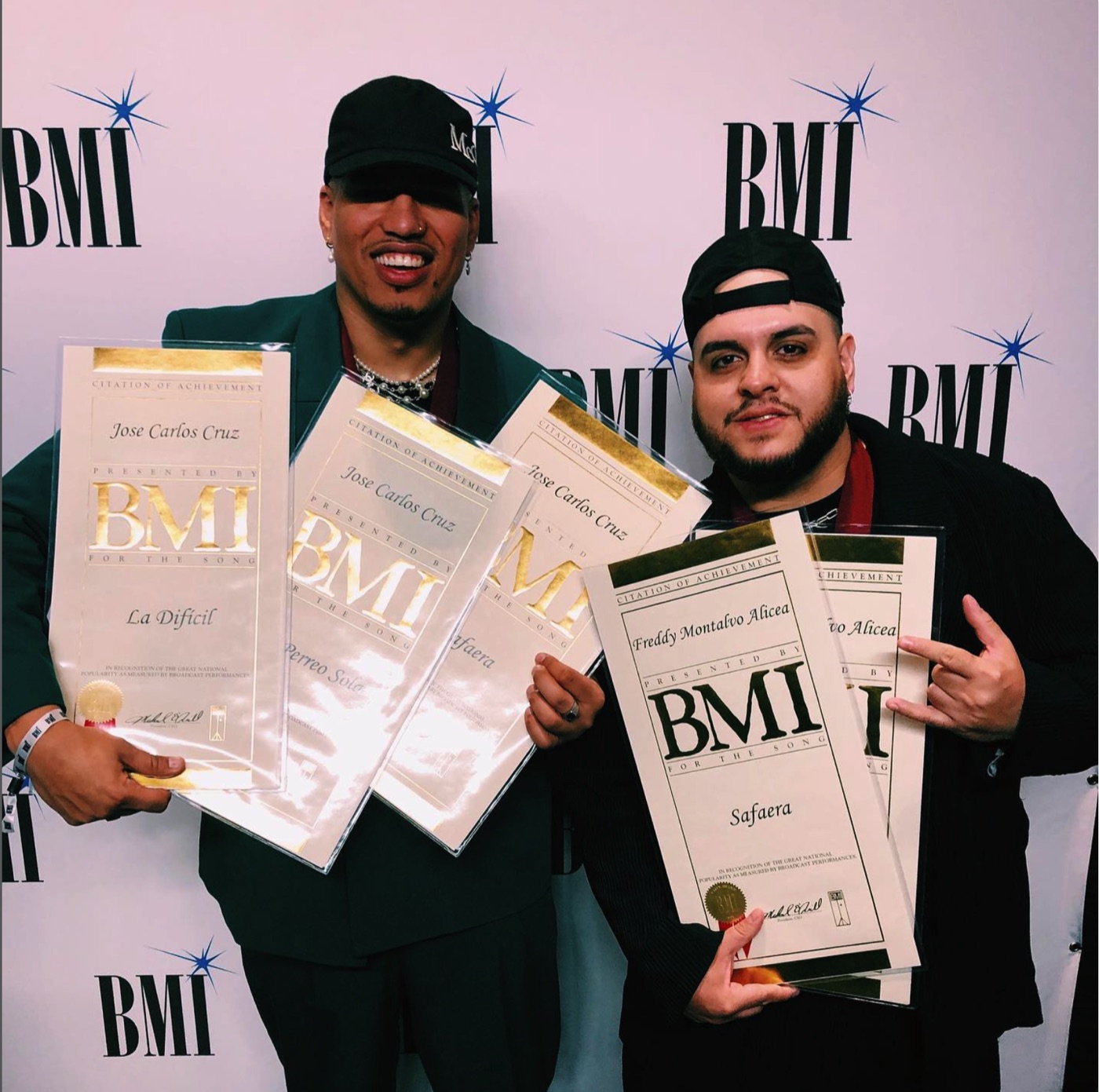 José “Phantom” Cruz and Freddy Montalvo Jr. holding BMI Citation of Achievement awards for La Difícil, Perreo Solo and Safaera